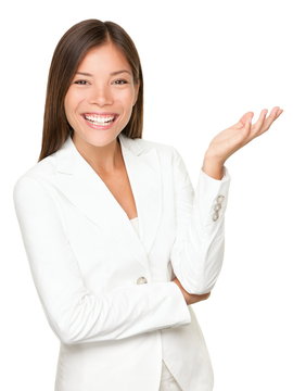 Asian Businesswoman Gesturing Open Hand Presenting On The Side Wearing White Suit Isolated. Business Woman In White Suit Smiling  Camera Explaining Showing Something.