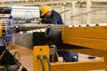 Worker using steel coil processing machine focus on machine.