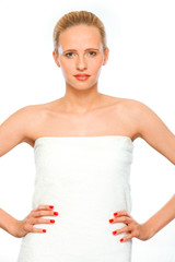 Young woman standing wrapped in white towel isolated on white.