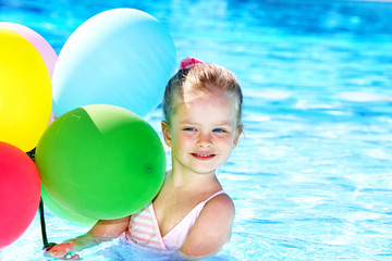 Obraz premium Child playing with balloons in swimming pool.