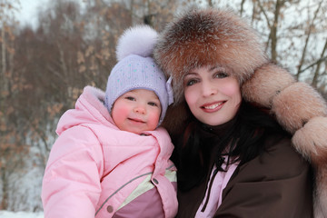Fototapeta premium mother hugs little daughter at winter, focus on woman