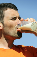 man is drinking fresh glass of milk in the blue skye