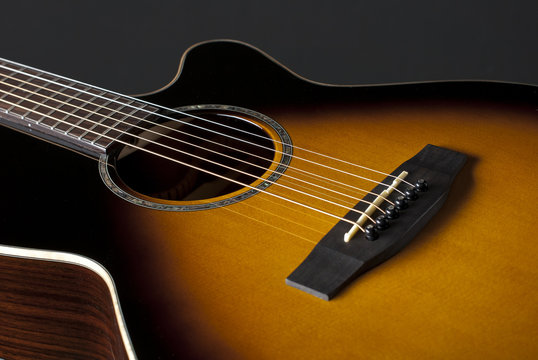 Acoustic guitar closeup on dark background