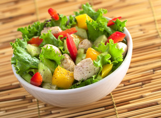 Chicken salad with lettuce, mango, bell pepper and cucumber