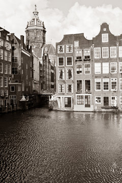 Amsterdam canal with houses and St. Nicholas Church
