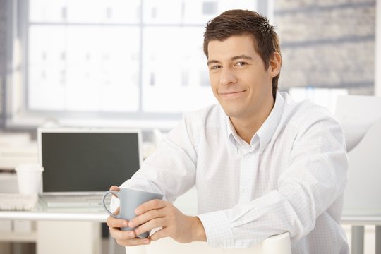 Portrait of content businessman with cup