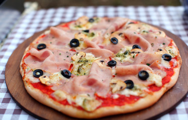 Pizza with fresh ham, mozzarella and black olives