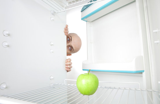 Man Looking At Apple In Fridge