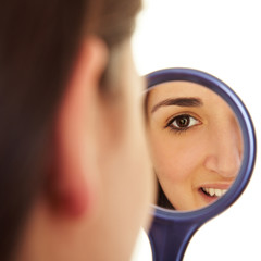 Junge Frau schaut in Spiegel