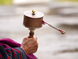An older women spinning her prayer wheel