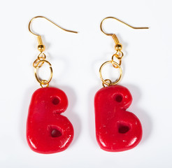 Earrings in the form of a letter B on a white background