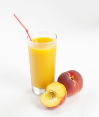 Glass with fresh peach juice near the slice peaches