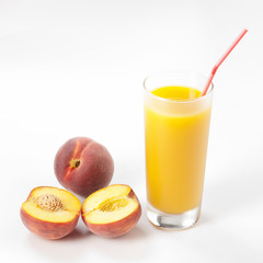 Glass with fresh peach juice near the slice peaches