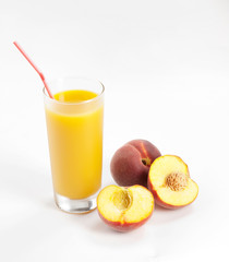 Glass with fresh peach juice near the slice peaches