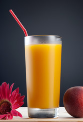Fresh peach juce in glass on dark background
