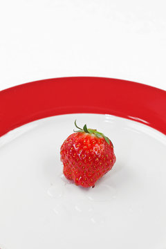 Einzelne Erdbeere auf einem Teller