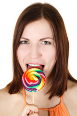 young brunette girl  licking big multicolored lollipop, isolated