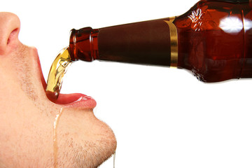 beer is being poured into the mouth from bottle