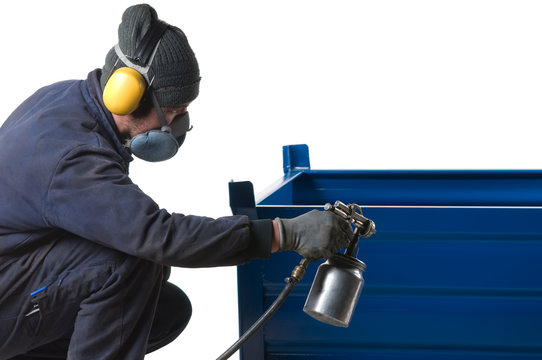 Industrial painter painting metal product with spray gun.
