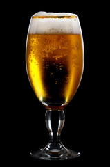 Beer into glass on a black