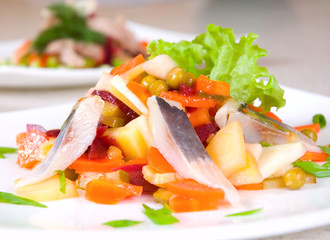 salad of beetroot, carrot, potato, green leek and herring