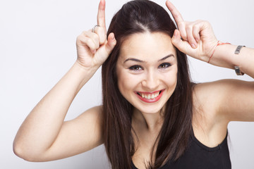 Funny playful woman showing devil horns