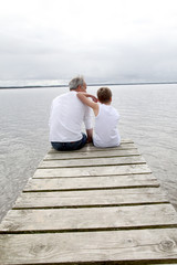 Portrait of father and son sitting on a pontoon