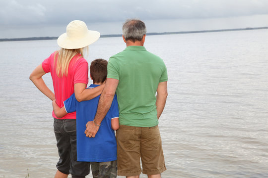 Family of three people on lake side