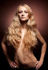 Fototapeta premium Fashion portrait of sensual young woman on brown background