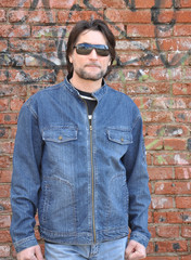 Obraz premium Portrait of a man in the background of an old brick wall