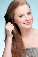Close up portrait of young beautiful woman with comb