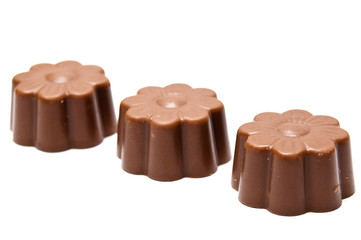 Three daisy shaped chocholate assortments in diagonal arrangemen