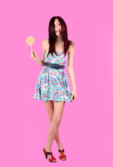 Glamorous girl wearing colorful dress with lollipop