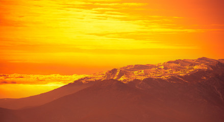 Fototapeta na wymiar Very beautiful bright orange sunrise over mountains