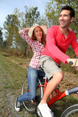 Couple riding bicycles in countryside