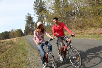 Fototapeta premium Couple riding bicycles in countryside