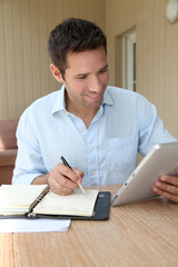 Man working at home with electronic tablet