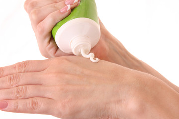 Closeup of beautiful female hands applying hand cream isolated o