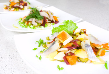 salad of beetroot, carrot, potato, green leek and herring