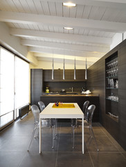 Moderna cucina di legno con tavolo bianco in mansarda