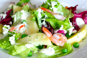 Salad leafs with potatoes, peas and king prawns