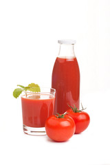 Tomatensaft im Glas mit Tomaten und Flasche