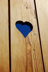 Heart shape hole in a wooden background, free copy space