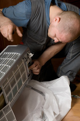 technician prepares a new air conditioner to be installed