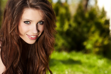 Naklejka premium Smiling beautiful woman laying on grass