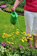 Seniorin gießt die Blumen