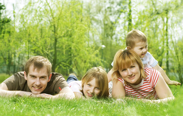 Fototapeta na wymiar Happy Family outdoor lying on green grass
