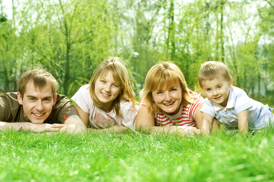 Happy Family outdoor lying on green grass