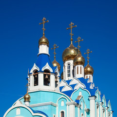 Fototapeta na wymiar Cupolas of Russian orthodox church against blue sky.
