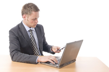 Manager arbeitet am Laptop und telefoniert